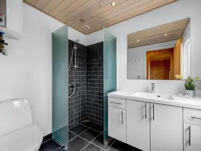 a bathroom with a white sink and a shower at Holiday Home Tanea - 700m to the fjord by Interhome in Lemvig