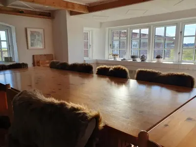 a large conference room with a large wooden table and chairs at Holiday Home Answald - 250m from the sea by Interhome in Harboør