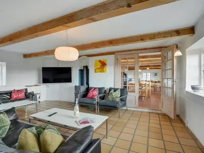 a living room with a couch and a table at Holiday Home Answald - 250m from the sea by Interhome in Harboør