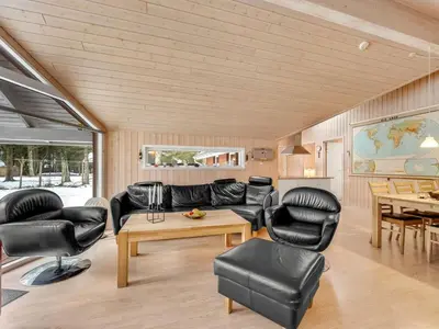 a living room with leather furniture and a table at Holiday Home Elfrun - 250m from the sea by Interhome in Harboør