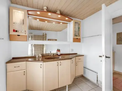 a kitchen with a sink and a mirror at Holiday Home Ali - 75m from the sea by Interhome in Harboør