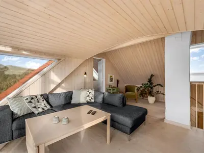 a living room with a couch and a table at Holiday Home Ali - 75m from the sea by Interhome in Harboør