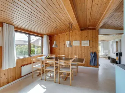 a dining room with wood paneling and a table and chairs at Holiday Home Suki - 650m from the sea by Interhome in Torsted