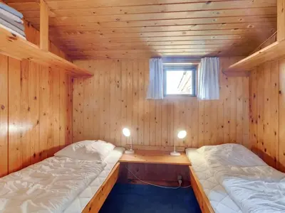 two beds in a wooden room with a window at Holiday Home Suki - 650m from the sea by Interhome in Torsted