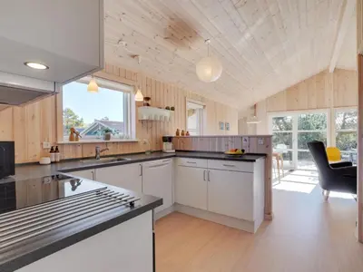 a kitchen with white cabinets and a black counter top at Holiday Home Gyrial - 950m from the sea by Interhome in Torsted