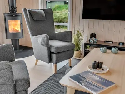 a living room with a chair and a coffee table at Holiday Home Gyrial - 950m from the sea by Interhome in Torsted