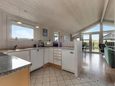 a kitchen with white cabinets and a large window at Holiday Home Suometar - 400m from the sea by Interhome in Torsted