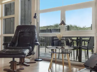 a living room with a chair and a table at Holiday Home Suometar - 400m from the sea by Interhome in Torsted