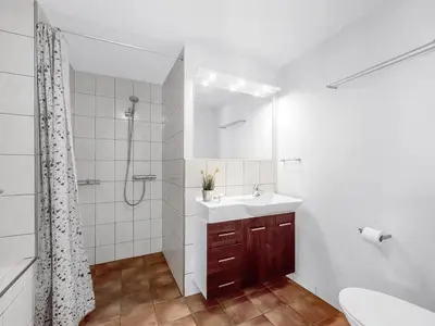 a white bathroom with a sink and a shower at Holiday Home Heming - 100m from the sea by Interhome in Thyborøn