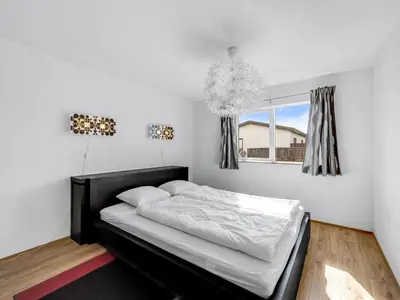 a bedroom with a black bed and a window at Holiday Home Heming - 100m from the sea by Interhome in Thyborøn
