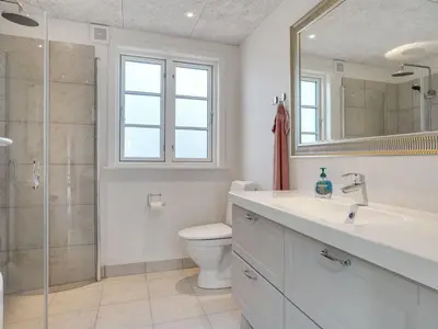 a bathroom with a toilet and a sink and a shower at Holiday Home Ibo - 900m from the sea by Interhome in Torsted