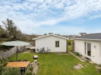 a backyard with a picnic table and an umbrella at Holiday Home Vilja - 150m from the sea by Interhome in Torsted