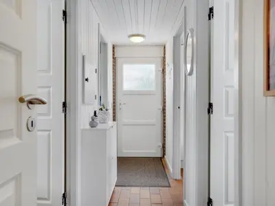 a hallway with a white door and a white floor at Holiday Home Aurelie - 800m from the sea by Interhome in Torsted