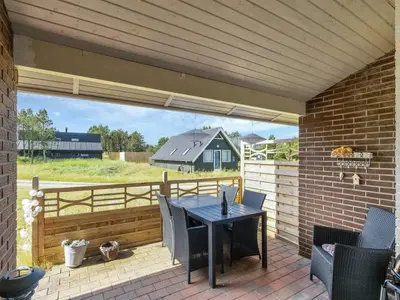 a patio with a table and chairs and a fence at Holiday Home Aurelie - 800m from the sea by Interhome in Torsted