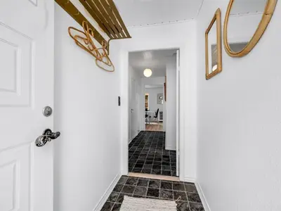 a hallway with white walls and black tile floors at Holiday Home Eluisa - 300m from the sea by Interhome in Thyborøn