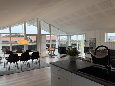 a kitchen and living room with a table and chairs at Holiday Home Mauri - 350m from the sea by Interhome in Torsted