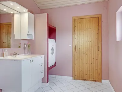 a bathroom with a sink and a wooden door at Holiday Home Jerg - 500m from the sea by Interhome in Torsted