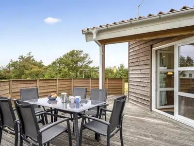 a patio with a table and chairs on a deck at Holiday Home Jerg - 500m from the sea by Interhome in Torsted