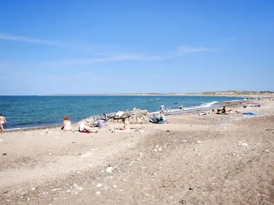a group of people on a beach near the ocean at Holiday Home Jerg - 500m from the sea by Interhome in Torsted