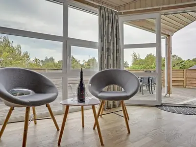 two chairs and a bottle on a table in a living room at Holiday Home Jerg - 500m from the sea by Interhome in Torsted