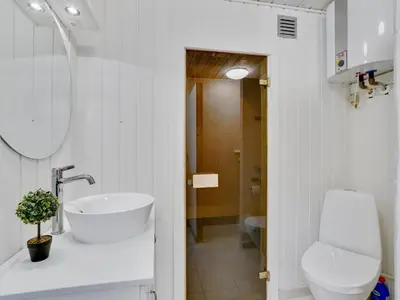 a white bathroom with a sink and a toilet at Holiday Home Styrmer - 1-2km from the sea by Interhome in Torsted