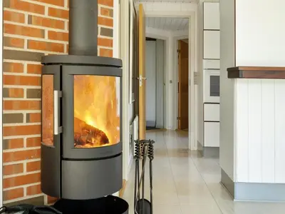 a fireplace in a room with a brick wall at Holiday Home Henkil - 700m from the sea by Interhome in Torsted