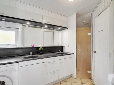 a white kitchen with white cabinets and a sink at Holiday Home Henkil - 700m from the sea by Interhome in Torsted