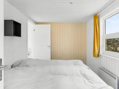 a bedroom with a white bed and a window at Holiday Home Antto - 900m from the sea by Interhome in Torsted