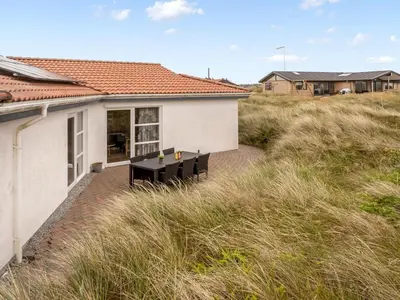 a house with a bench in the middle of a field at Holiday Home Palli - 600m from the sea by Interhome in Torsted