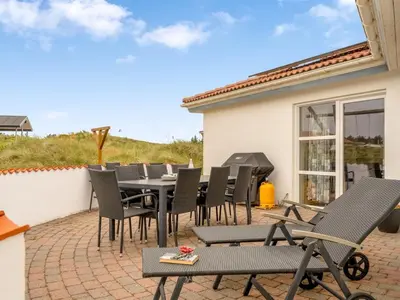 a patio with a table and chairs and a grill at Holiday Home Palli - 600m from the sea by Interhome in Torsted