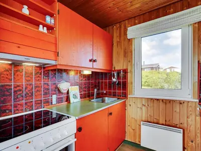 a kitchen with red cabinets and a window at Holiday Home Usko - 250m from the sea by Interhome in Torsted