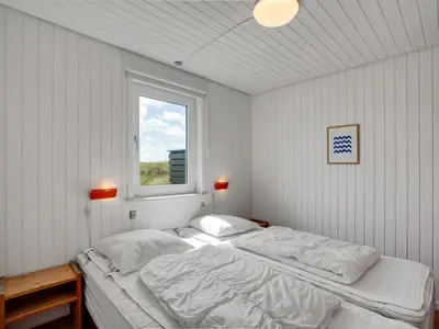 a white bedroom with two beds and a window at Holiday Home Usko - 250m from the sea by Interhome in Torsted