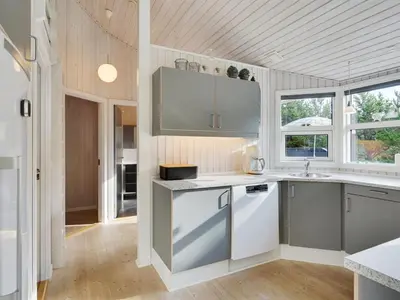 a kitchen with white and gray appliances and windows at Holiday Home Alethe - 1km from the sea by Interhome in Torsted