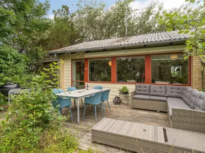 a house with a patio with a table and chairs at Holiday Home Flor - 900m from the sea by Interhome in Torsted