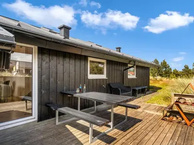 a wooden deck with a picnic table on a house at Holiday Home Suleika - 900m from the sea by Interhome in Torsted