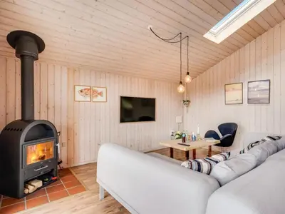 a living room with a couch and a fireplace at Holiday Home Suleika - 900m from the sea by Interhome in Torsted