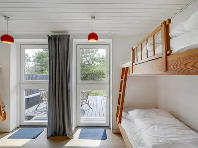a bedroom with a bunk bed and a balcony at Holiday Home Fidelia - 800m from the sea by Interhome in Torsted