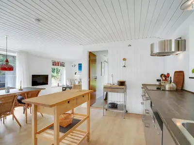 a kitchen with a wooden table and a dining room at Holiday Home Fidelia - 800m from the sea by Interhome in Torsted