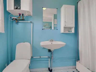 a blue bathroom with a toilet and a sink at Holiday Home Tayanita - 750m from the sea by Interhome in Torsted