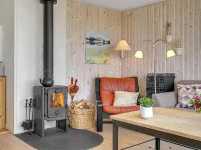 a living room with a wood stove and a couch at Holiday Home Tayanita - 750m from the sea by Interhome in Torsted
