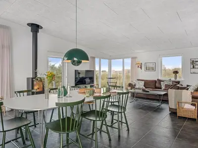 a dining room and living room with a table and chairs at Holiday Home Pontus - 400m from the sea by Interhome in Torsted