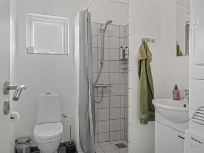 a white bathroom with a shower and a toilet at Holiday Home Pontus - 400m from the sea by Interhome in Torsted