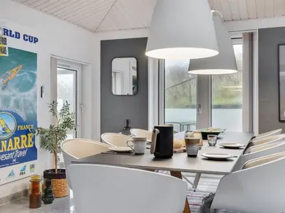 a dining room with a table and white chairs at Holiday Home Fris - 100m from the sea by Interhome in Torsted