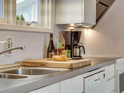 a kitchen counter with a cutting board and bottles of wine at Holiday Home Stener - 250m from the sea by Interhome in Torsted
