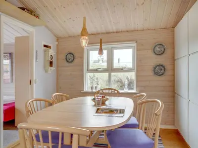 a dining room with a wooden table and chairs at Holiday Home Stener - 250m from the sea by Interhome in Torsted