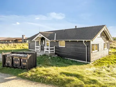 a house with two trash cans in front of it at Holiday Home Horsten - 350m from the sea by Interhome in Torsted