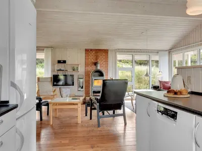 a kitchen and living room with a table and chairs at Holiday Home Annemia - 200m from the sea by Interhome in Torsted