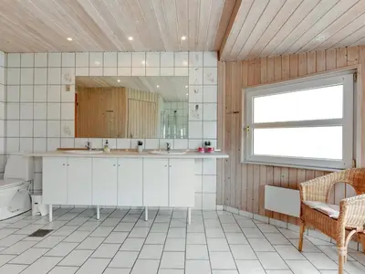 a kitchen with a sink and a mirror and a window at Holiday Home Annemia - 200m from the sea by Interhome in Torsted