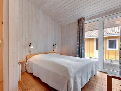 a bedroom with a bed and a large window at Holiday Home Annemia - 200m from the sea by Interhome in Torsted