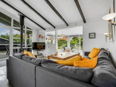 a living room with a large gray couch and yellow pillows at Holiday Home Gerlis - 75m from the sea by Interhome in Torsted